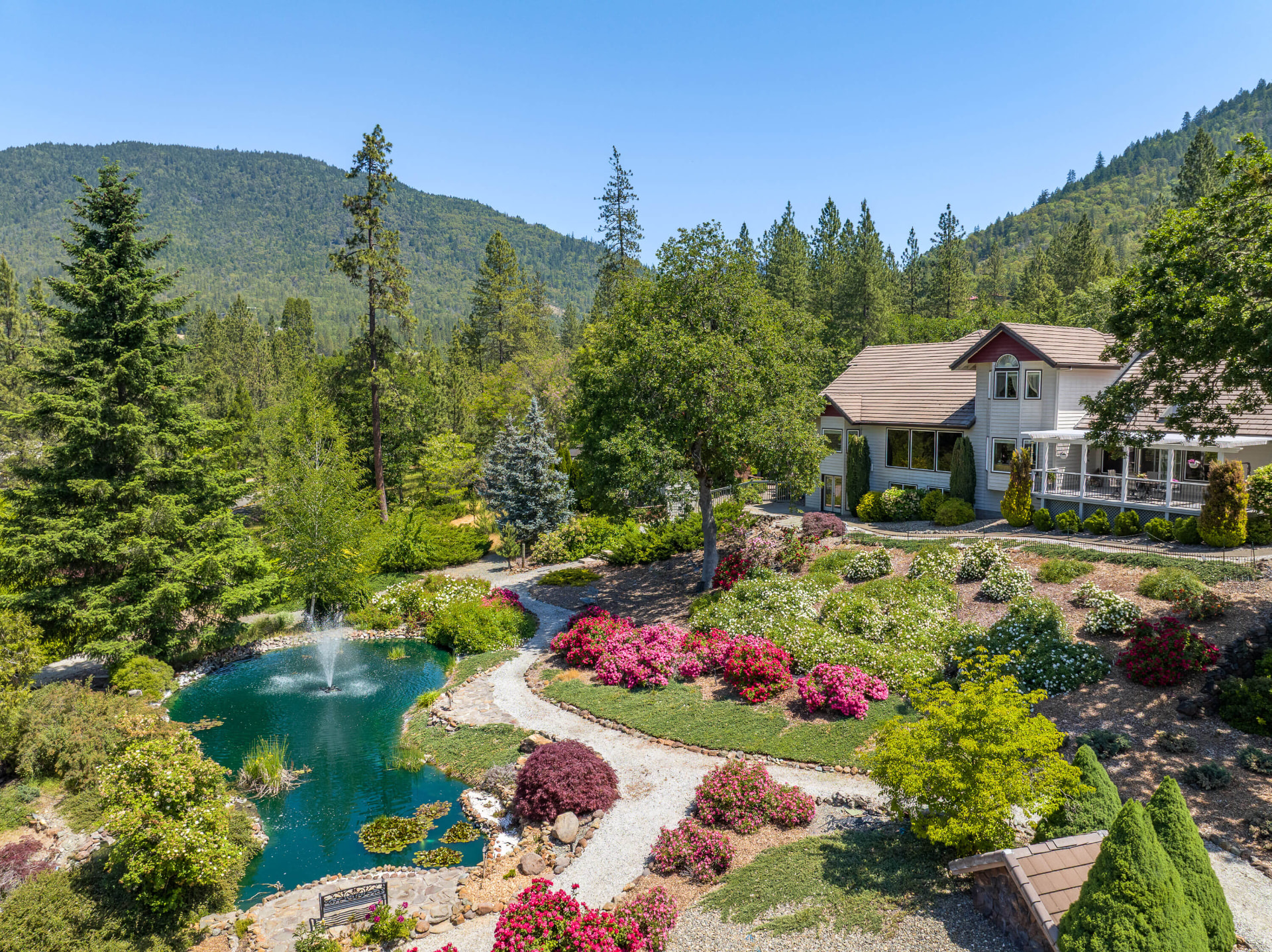 Elevated view of the gardens and fountain pond, with the house at right